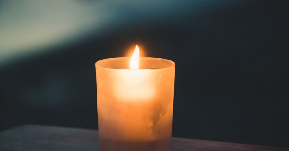 暗い背景の中でやさしく灯るキャンドルの炎