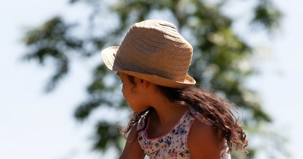 後ろを振り返る帽子をかぶった少女